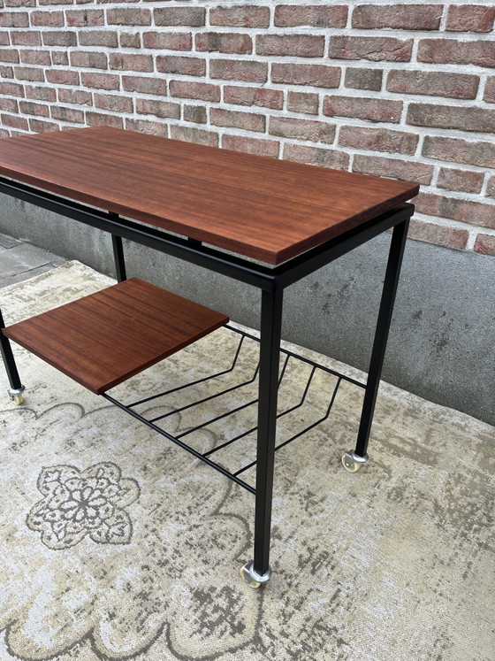 Image 1 of Mueble estéreo antiguo de teca con estructura de metal negro y ruedas giratorias.