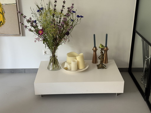 Two white plant tables with steel adjustable legs