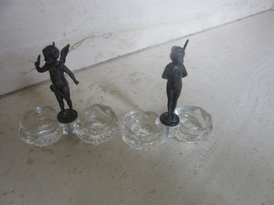 Image 1 of 2 recipientes para salero y pimentero con forma de ángeles querubines de cristal y metal negro (a uno de ellos le falta un ala) 