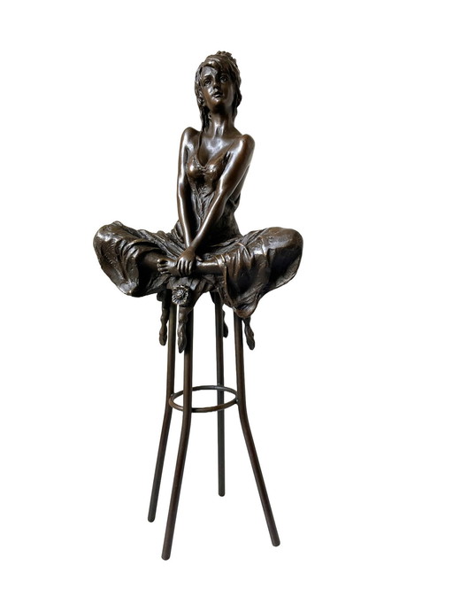 Statue en bronze d'une dame sur un tabouret de bar