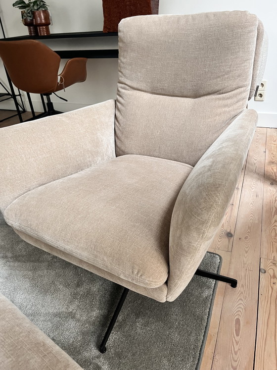 Image 1 of Amy est assise dans un fauteuil avec un repose-pieds.