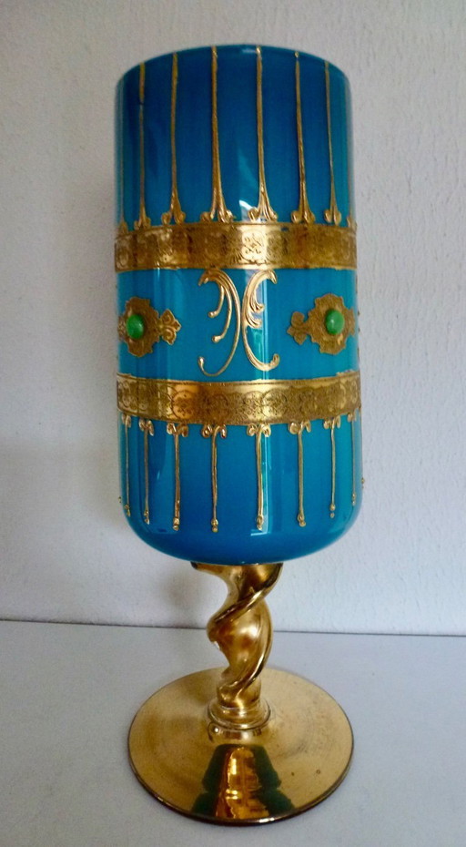 Vintage blauer Glasbecher oder Kelch in Türkis mit Goldverzierungen.