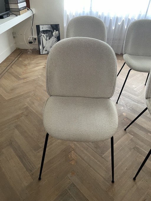 Sillas de comedor Gubi Beetle, totalmente tapizadas con base negra.