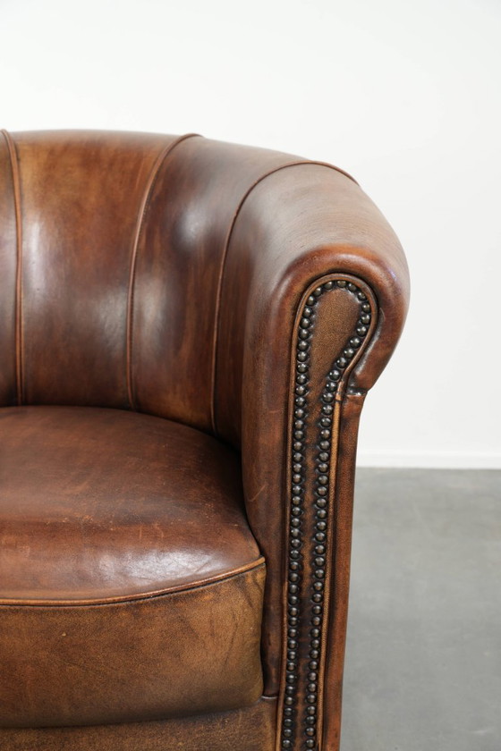 Sturdy and characterful sheepskin club armchair with a beautiful patina, finished with decorative nails. (photo 9 of 12)