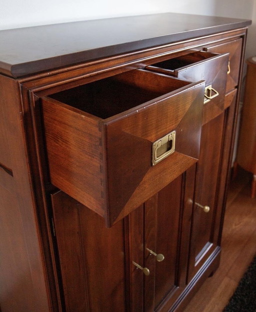 Cherry wood tableware cupboard with three doors and drawers.