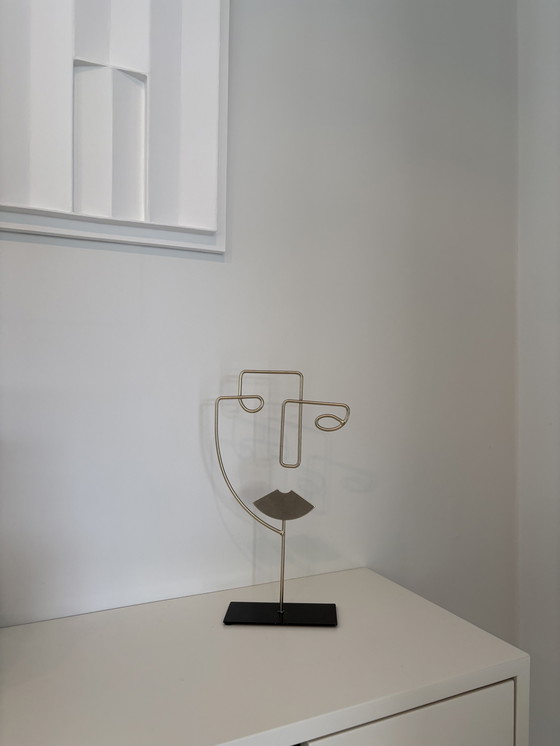 Image 1 of Scultura moderna in filo metallico raffigurante un volto stilizzato, di colore oro