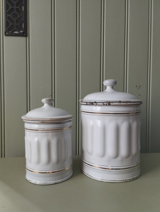 Image 1 of Antieke dozen gemaakt van wit geëmailleerd plaatmetaal met gegroefde randen en gouden versiering.