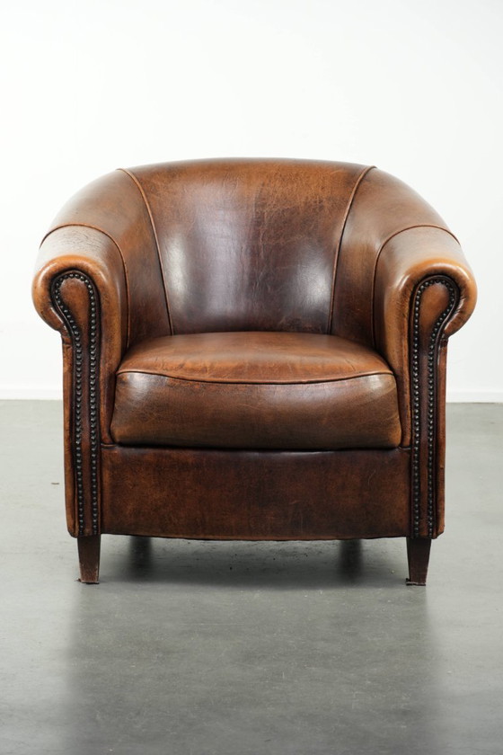 Image 1 of Karaktervolle en comfortabele clubfauteuil gemaakt van schapenleer met een vast zitkussen en uitmuntende kleuren