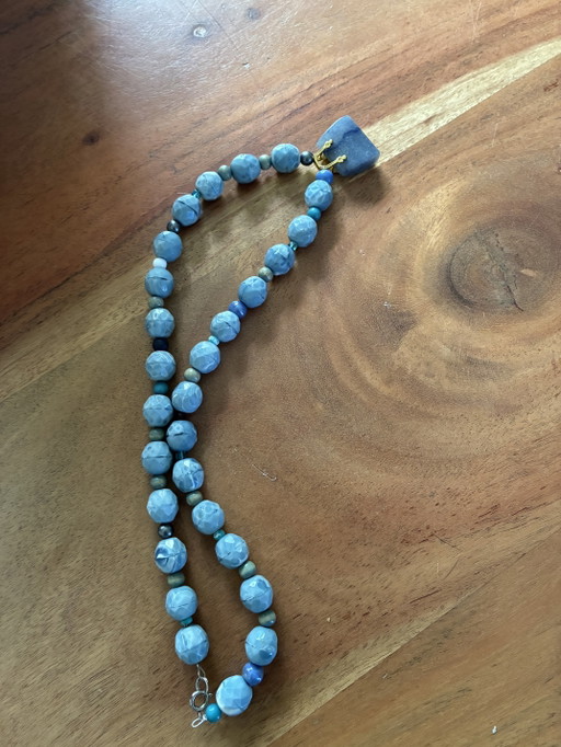 New necklace with blue vintage beads and a small agate bag as a pendant