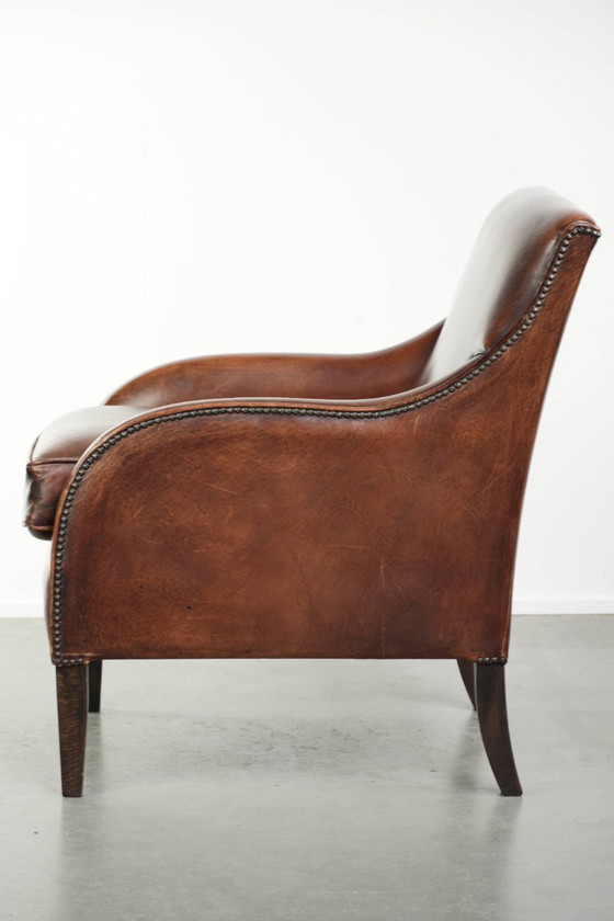 Image 1 of Bellissima poltrona in pelle di pecora in buone condizioni, con un bel colore intenso e una seduta confortevole.