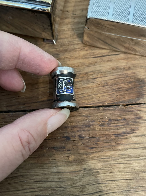 Estuches para cigarrillos y apagavelas, chapados en plata.
