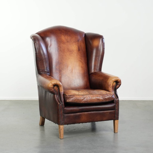 Comfortabele rundleren oorfauteuil in Engelse stijl met een prachtige warme kleurstelling en een karaktervolle uitstraling