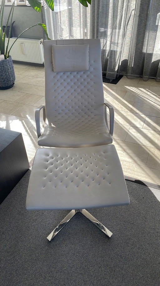 Sillón Sede con reposapiés color crema.