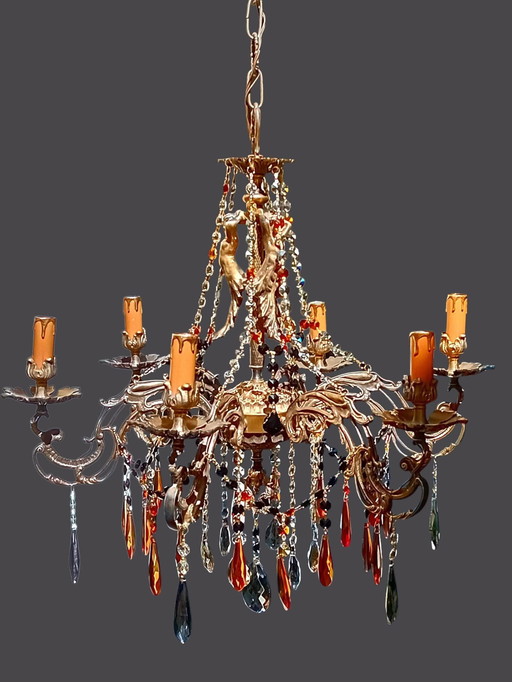 Una gran lámpara de araña de latón fundido con pátina.