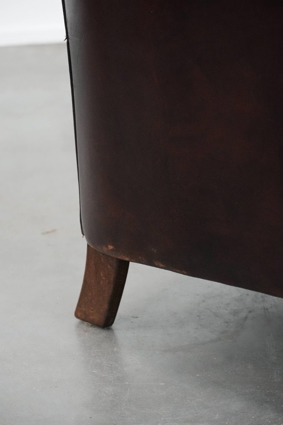 Image 1 of Sillón club marrón oscuro de piel de oveja con ribete fotocromático.