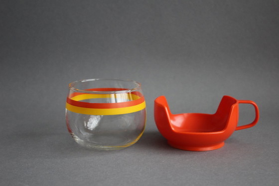 Image 1 of 12 vintage glazen theekopjes met geel-oranje strepen en oranje plastic houders.