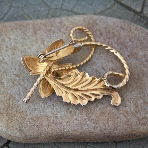 Spilla vintage a forma di fiore con perle in smalto giallo, incastonata su metallo color oro.