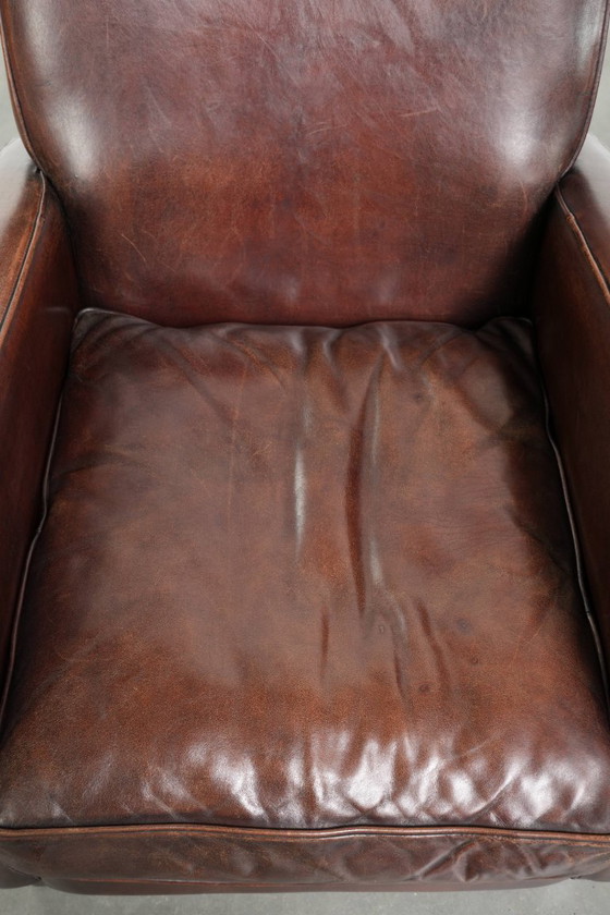 Image 1 of 2x dunkel cognacfarbene Schaffellsessel mit abgerundeten Formen und elegantem Design