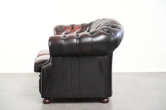 Image 1 of Canapé Chesterfield 2 places en cuir de vachette anglais ancien rouge/marron, au style magnifique et au charme intemporel.