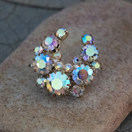 Broche vintage Aurore Boréale : bijou ancien en forme de fer à cheval orné de strass irisés