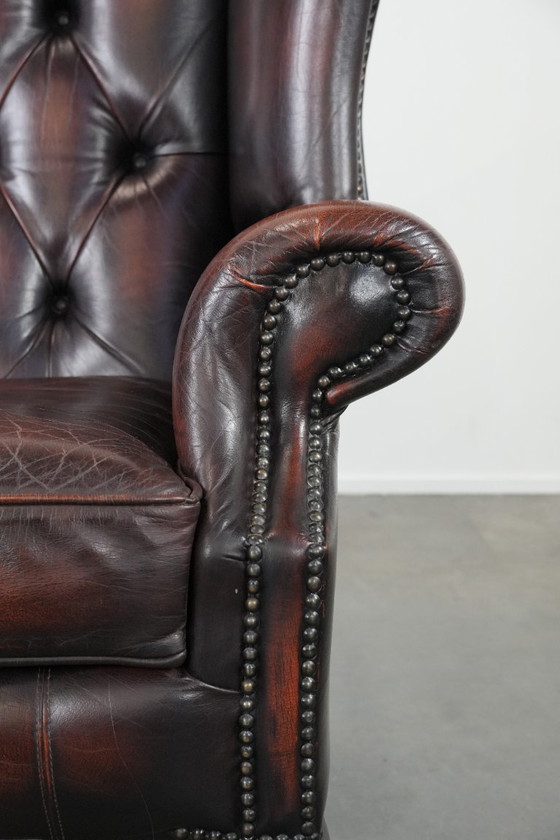 Image 1 of Poltrona Chesterfield con braccioli in pelle bovina marrone, in classico stile inglese.