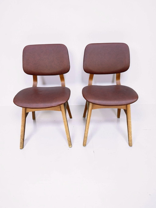Juego de 2 sillas de comedor vintage con tapicería de piel sintética marrón rojiza.