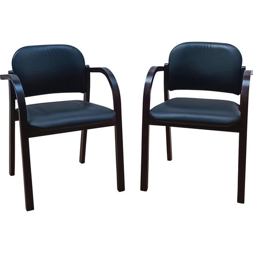Paar vintage stoelen van zwart gebeitst hout met zitting en rugleuning bekleed met zwart skai