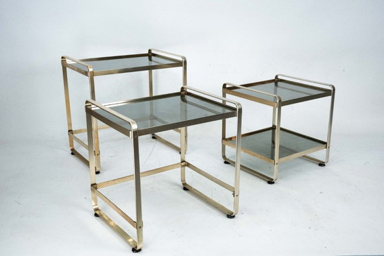 Image 1 of Ensemble de trois tables d'appoint gigognes en aluminium doré et verre – Italie, années 1970