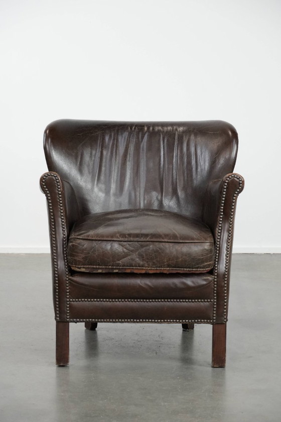 Image 1 of Subtiele donkerbruine fauteuil gemaakt van rundleer met een omkeerbaar Kelim zitkussen