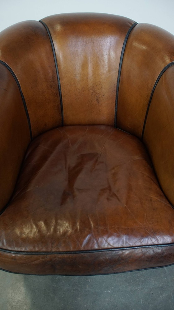 Image 1 of Unieke vintage cognac kleurige lederen clubfauteuil met een afwerking met zwarte biezen
