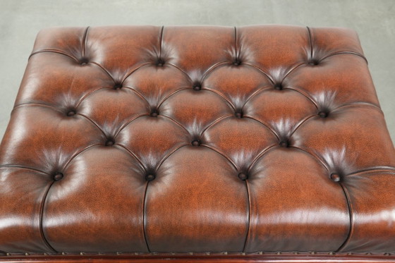 Image 1 of Grote bruine rundleren chesterfield hocker in Engelse stijl met sierlijke poten en messing wieltjes