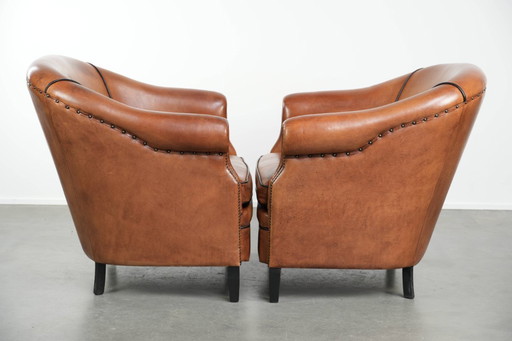 2 grands fauteuils club en peau de mouton, en bon état