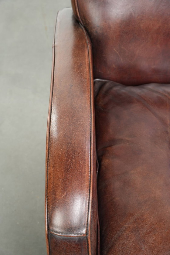 Image 1 of 2x dunkel cognacfarbene Schaffellsessel mit abgerundeten Formen und elegantem Design
