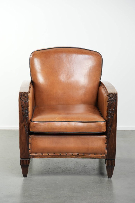 Image 1 of Schapenleren art Deco fauteuil met mooi houtsnijwerk en zwarte biezen