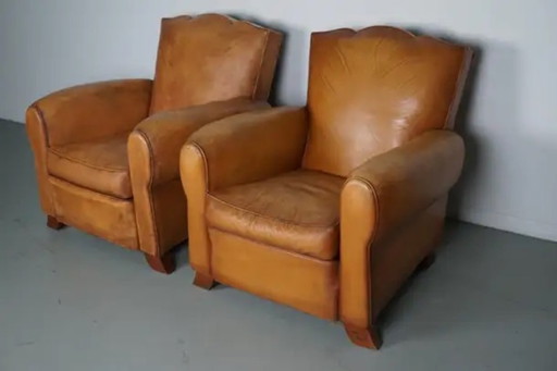 Conjunto de sillones de club franceses de cuero color coñac con respaldos en forma de bigote, años 50
