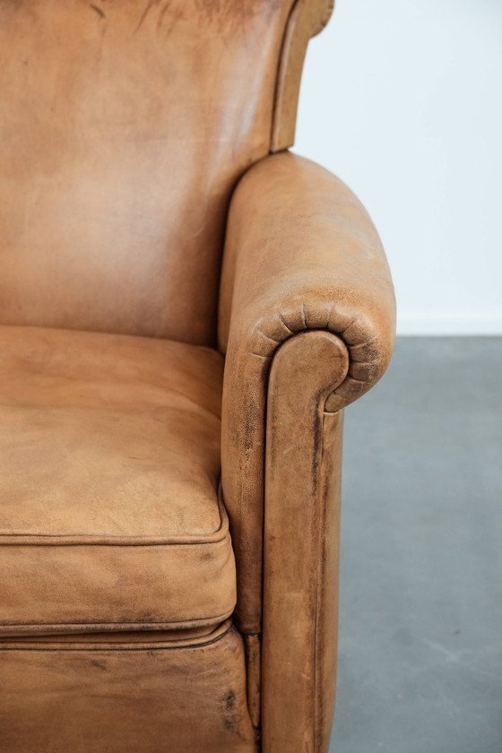 Image 1 of Fauteuil vintage discret en peau de mouton aux pieds gracieux