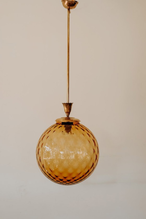 Brass Pendant Lamp with Round Orange Glass Shade and Swirl Structure (photo 7 of 8)