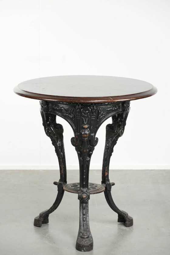 Image 1 of Antieke Engelse pub/ bistro/ bijzettafel uit de 19e eeuw met een gietijzeren onderstel en een rond houten tafelblad