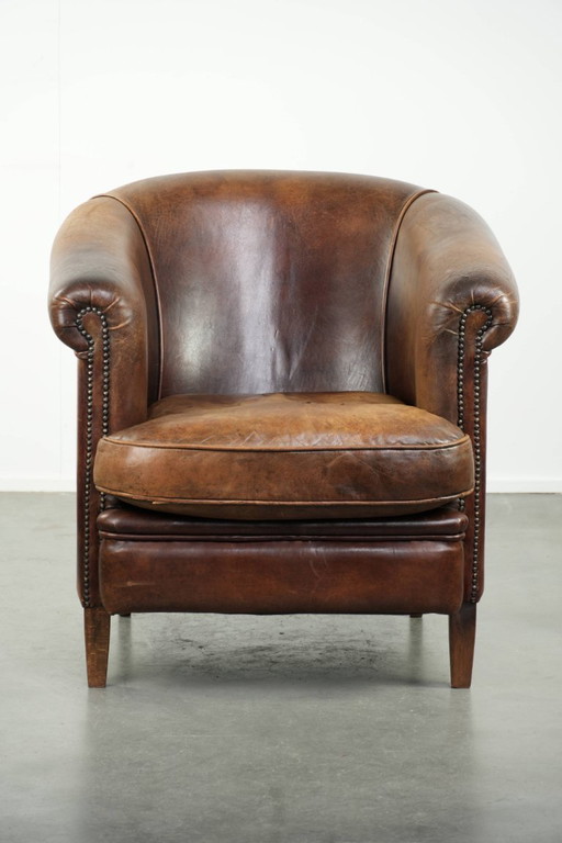 Sturdy and desirable vintage sheepskin club armchair with a beautiful patina and warm colors