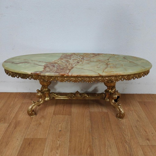 Table basse ovale avec plateau en marbre et piètement doré orné