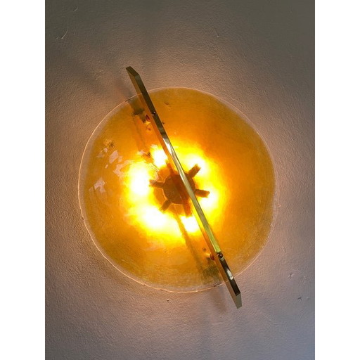 Aplique de pared italiano con disco de cristal de Murano ámbar y marco de metal de latón.