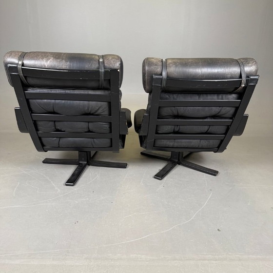 Image 1 of Pair of black leather, metal and wood Mid-Century Modern spinning armchairs in good condition with small signs of aging, 2 items