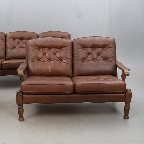 Image 1 of A vintage brown three-piece sofa set in leather with wooden armrests and turned legs, comprising a 1-seater, 2-seater and 3-seat