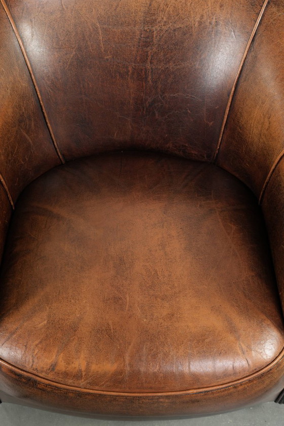 Image 1 of Karaktervolle en comfortabele clubfauteuil gemaakt van schapenleer met een vast zitkussen en uitmuntende kleuren