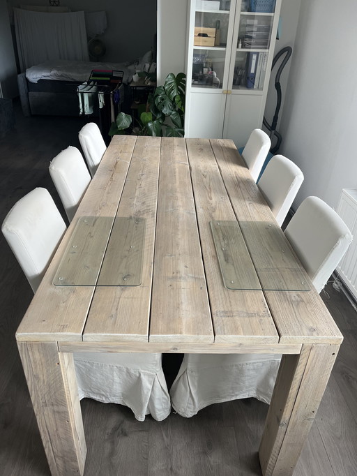 Robuuste massief houten eettafel met 6 bijpassende stoelen.