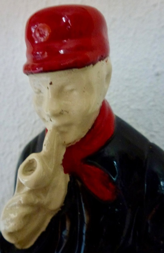 Image 1 of A set of decorative bookends depicting an elderly couple sitting on chairs.