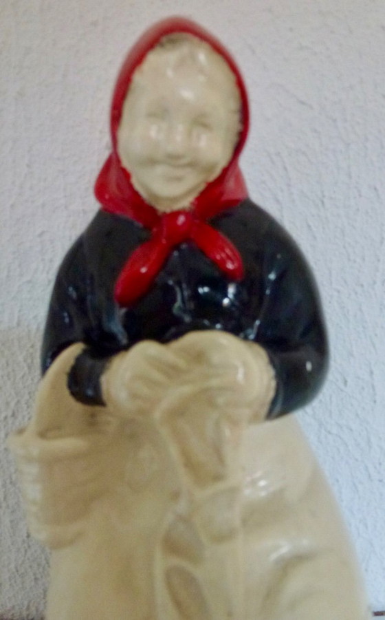 Image 1 of A set of decorative bookends depicting an elderly couple sitting on chairs.