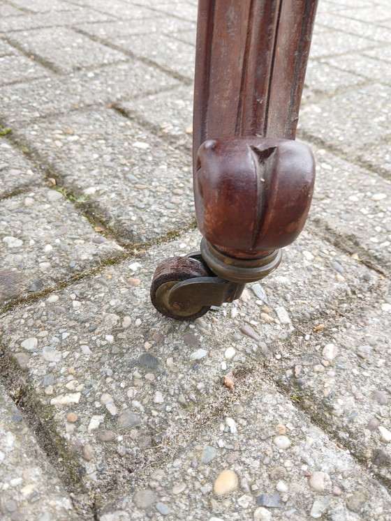 Image 1 of The antique dining table is made of mahogany and has a Louis XV style.