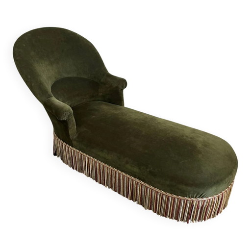 Chaise longue vintage de terciopelo verde oscuro con flecos multicolores.