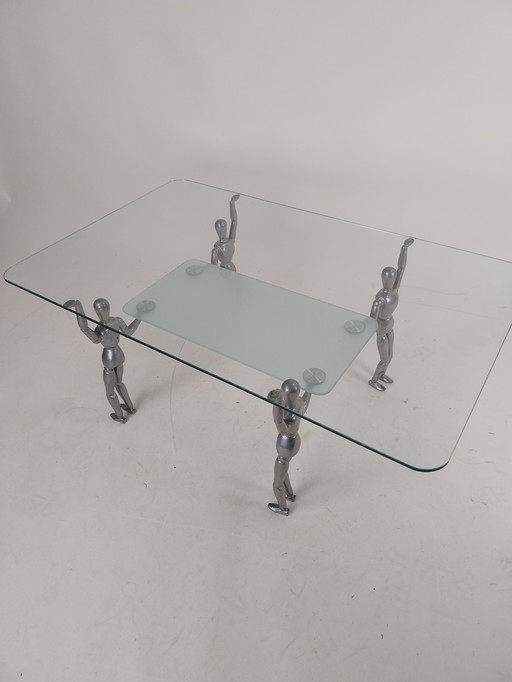 1 x Glas-Couchtisch, getragen von 4 Aluminium-Puppen aus den 1980er Jahren